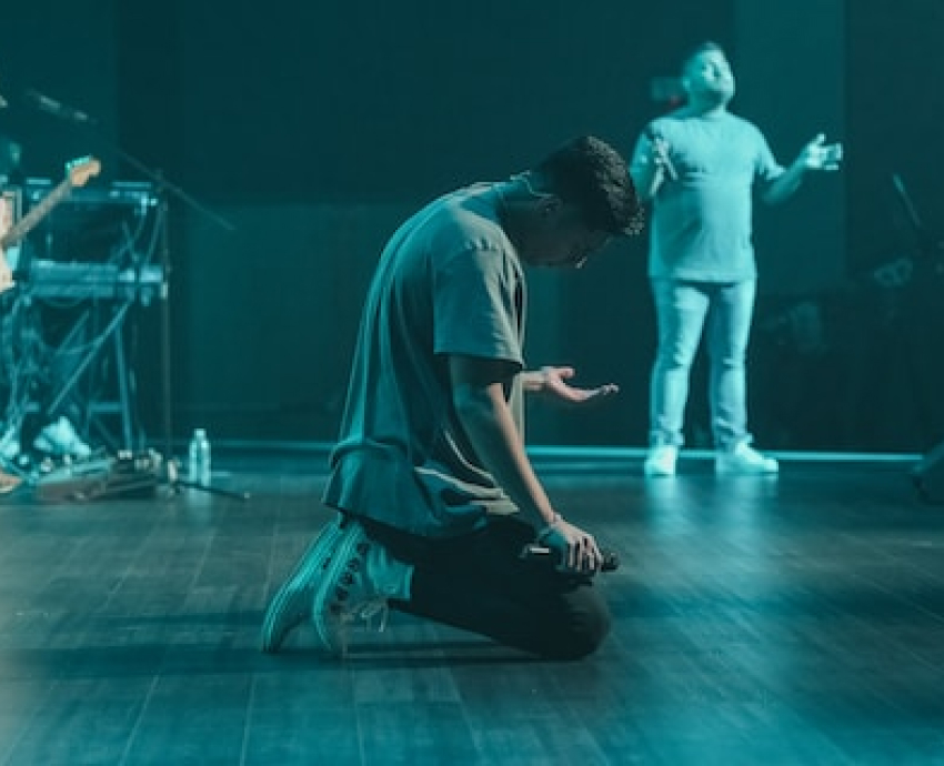 A man kneeling during a worship service at Village Heights Church