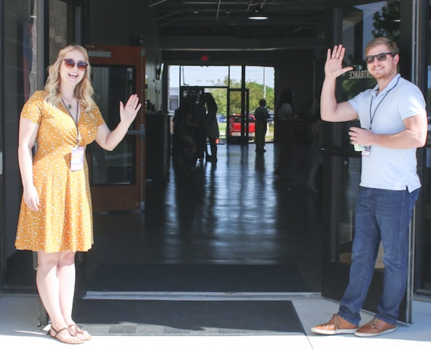 A man and woman greeting people to Village Heights Church in Houston